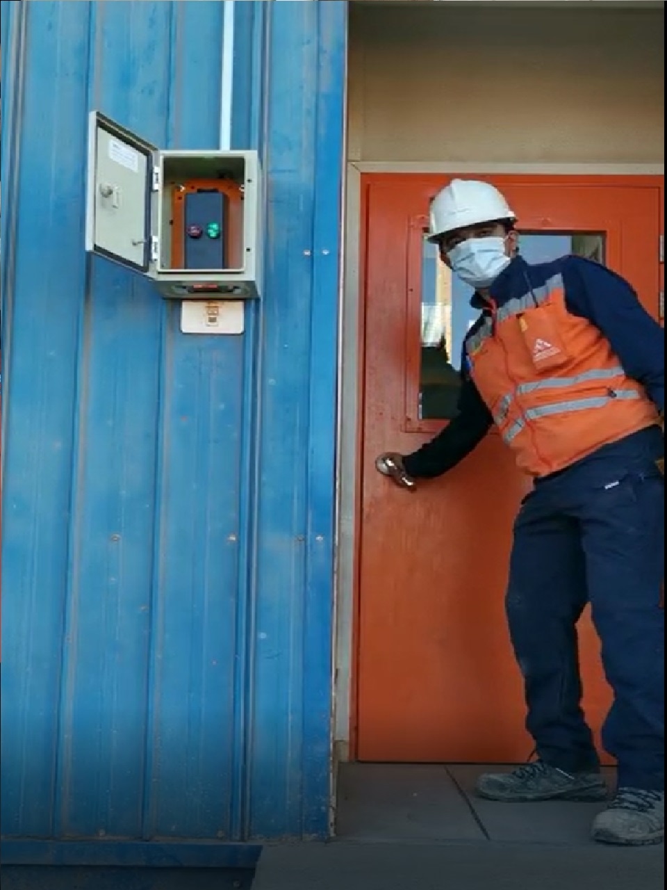 Sistema protegido de control de acceso instalado junto a una puerta industrial